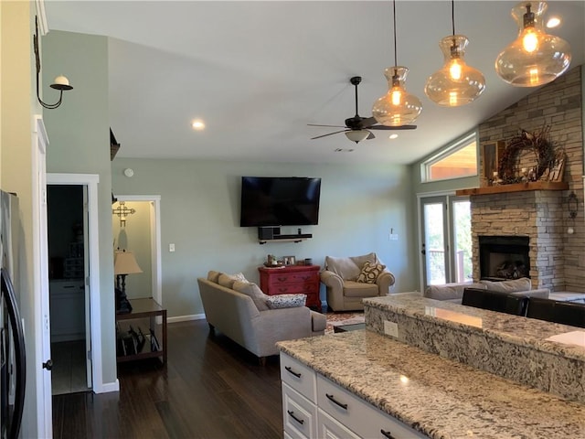 kitchen featuring a fireplace, dark wood-style flooring, ceiling fan, white cabinets, and open floor plan