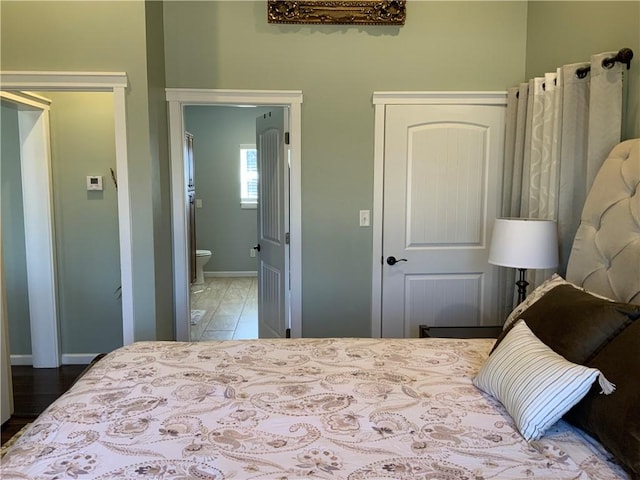 bedroom with baseboards and ensuite bathroom