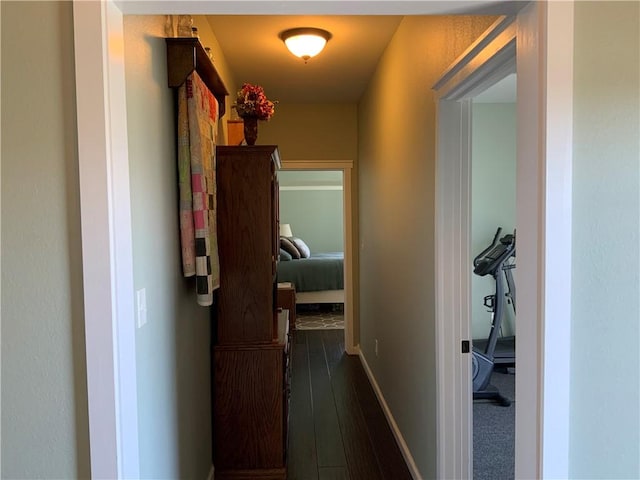 hallway with baseboards and dark wood-type flooring