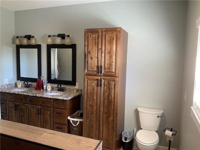 full bath featuring a sink, toilet, and double vanity