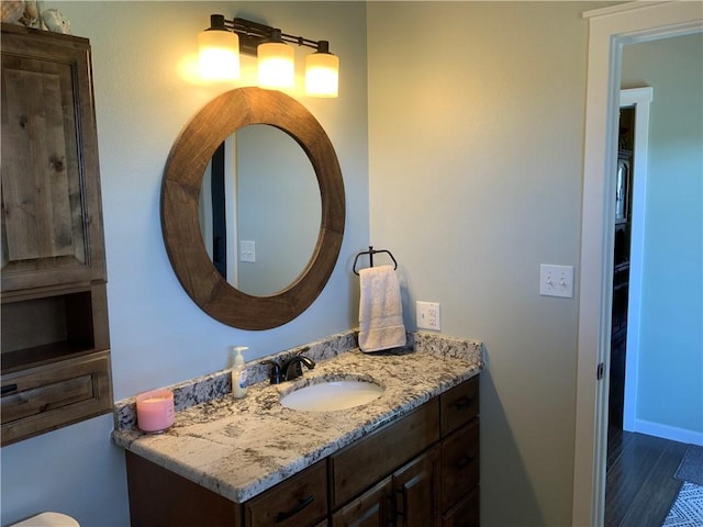 bathroom with vanity, baseboards, and wood finished floors