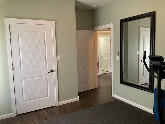 corridor with baseboards and dark wood-style flooring