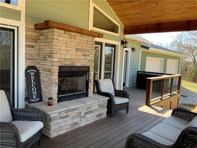 wooden deck with an outdoor stone fireplace