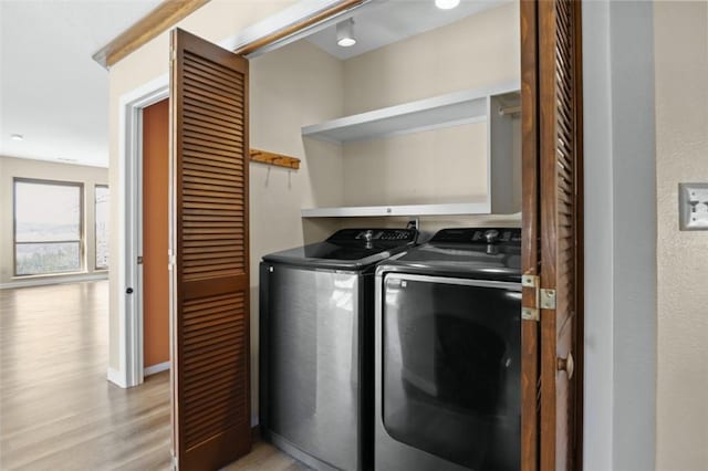 laundry area featuring washer and dryer, laundry area, and light wood-style floors