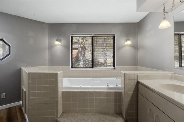 full bathroom with a bath, vanity, and wood finished floors