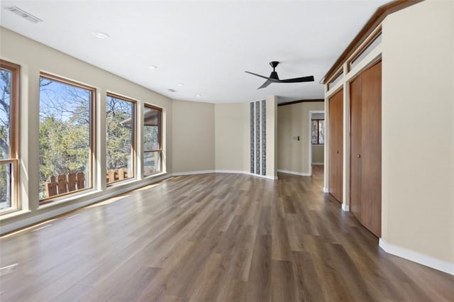 unfurnished living room featuring baseboards, wood finished floors, and a ceiling fan