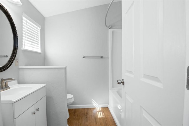 full bathroom with vanity, washtub / shower combination, wood finished floors, baseboards, and toilet