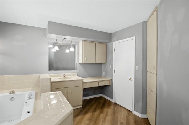 clothes washing area with wood finished floors, baseboards, and a sink