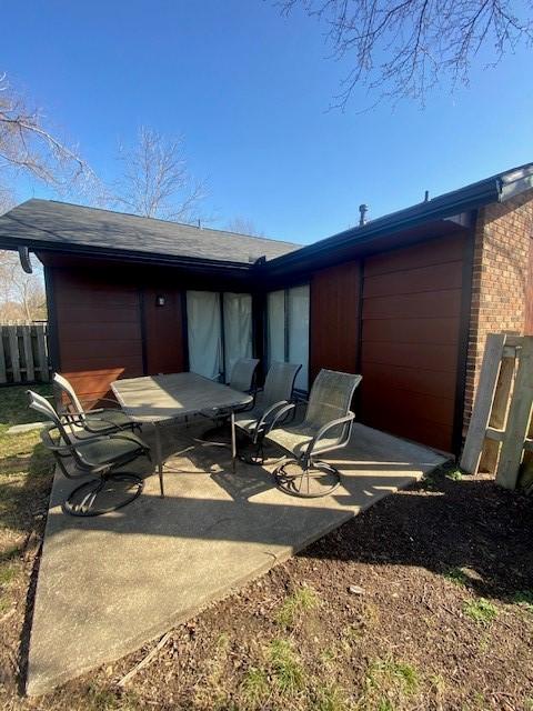 back of house with fence, a patio area, and brick siding