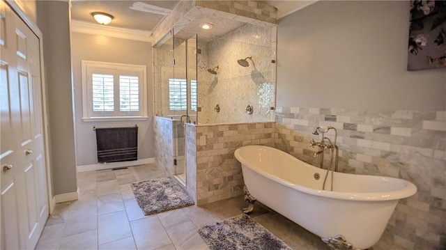 bathroom featuring tile patterned flooring, crown molding, a freestanding bath, a stall shower, and tile walls