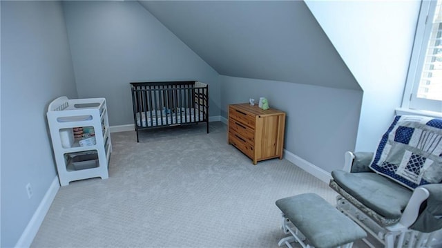 living area featuring light carpet, lofted ceiling, and baseboards