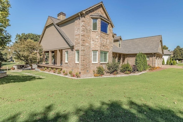 view of side of home featuring a lawn, brick siding, and a chimney