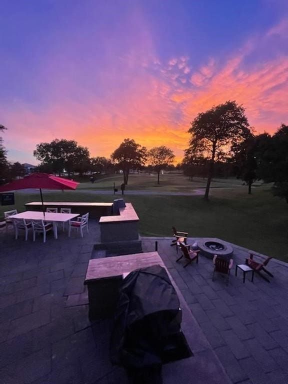 patio terrace at dusk with a fire pit and outdoor dining area