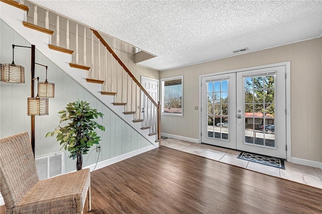 entryway with wood finished floors, visible vents, and a textured ceiling