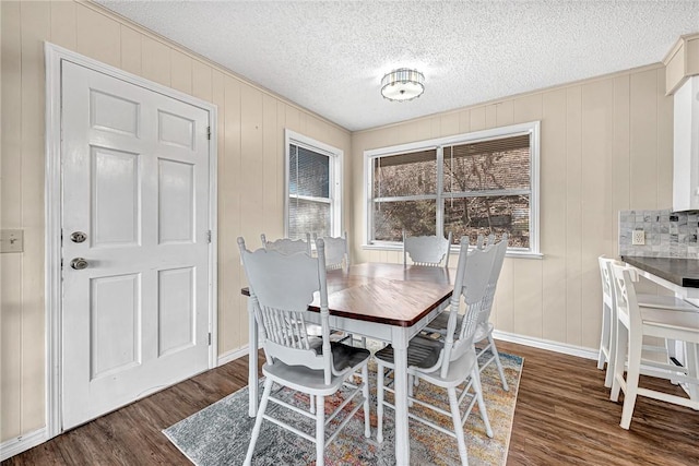 dining space with wood finished floors, baseboards, and a textured ceiling