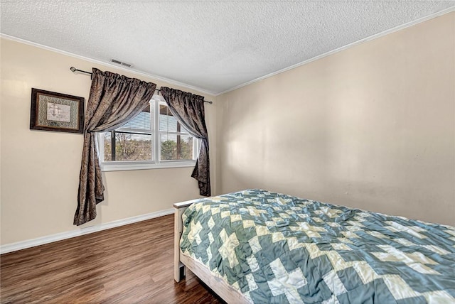 bedroom with visible vents, wood finished floors, and crown molding