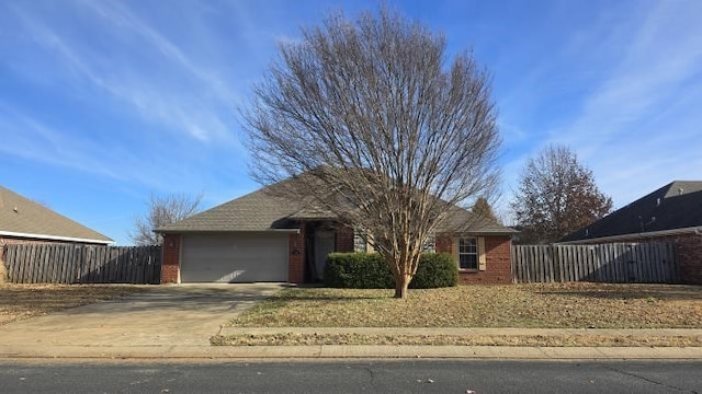 single story home featuring brick siding, concrete driveway, an attached garage, and fence