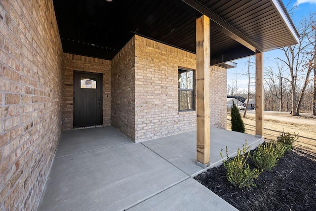 view of exterior entry featuring brick siding