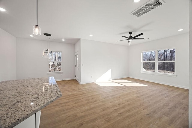 unfurnished living room featuring visible vents, recessed lighting, light wood-style floors, baseboards, and ceiling fan