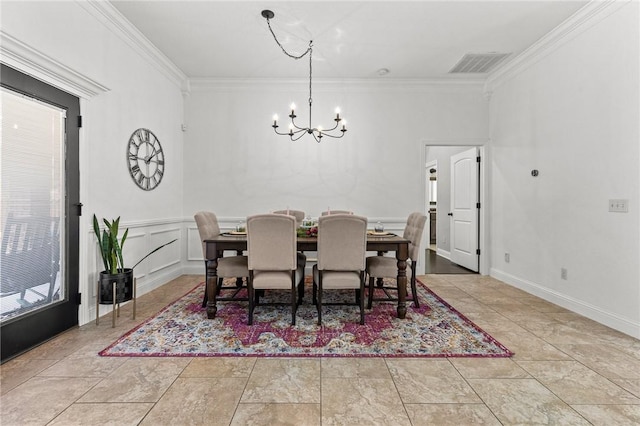 dining area featuring visible vents, an inviting chandelier, ornamental molding, wainscoting, and a decorative wall