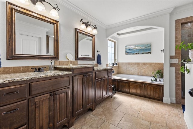 full bath featuring vanity, a garden tub, and ornamental molding