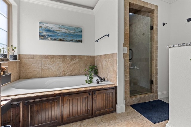 bathroom featuring tile patterned flooring, a shower stall, a garden tub, and ornamental molding