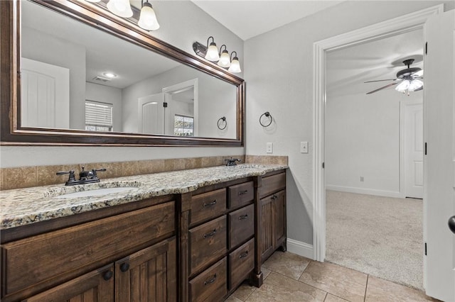 full bathroom featuring double vanity, baseboards, ceiling fan, and a sink