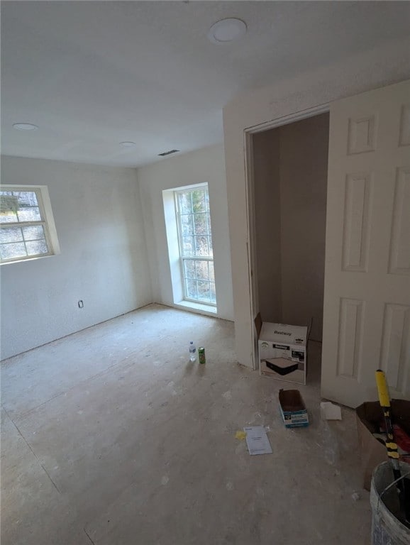 unfurnished room featuring plenty of natural light and visible vents