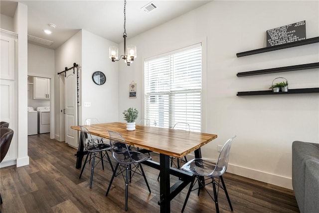 dining room with dark wood finished floors, visible vents, a barn door, and separate washer and dryer