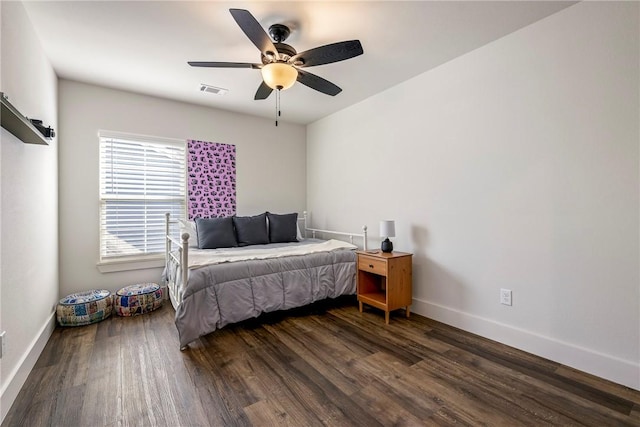 bedroom with ceiling fan, visible vents, baseboards, and wood finished floors