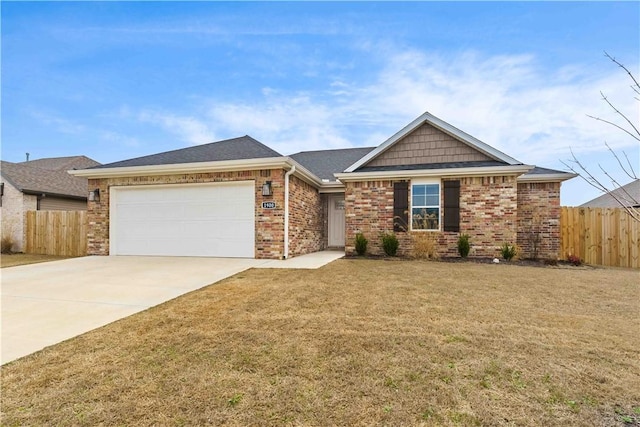 view of front of property with driveway, brick siding, an attached garage, and fence