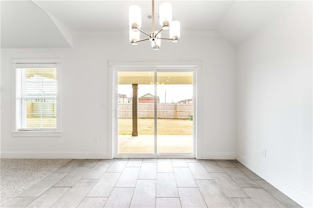 interior space featuring baseboards, a chandelier, crown molding, and vaulted ceiling