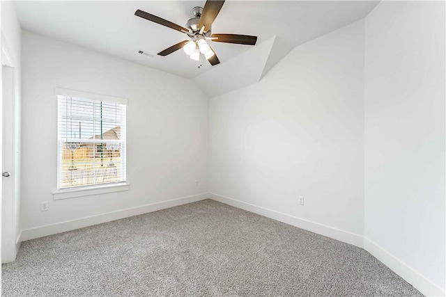 carpeted empty room with visible vents, a ceiling fan, baseboards, and vaulted ceiling