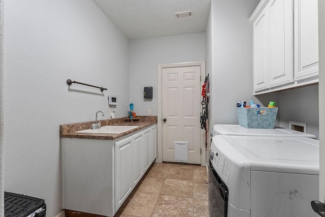 washroom with washing machine and clothes dryer, visible vents, cabinet space, and a sink