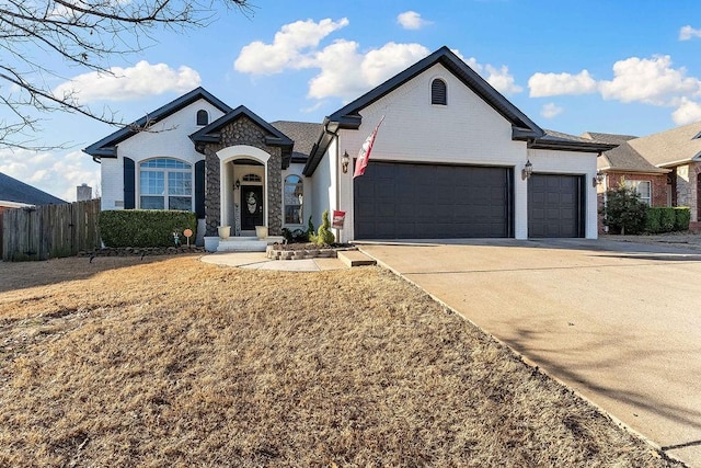 view of front of house featuring brick siding, concrete driveway, fence, and a garage