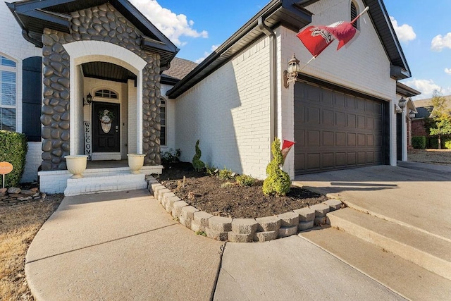 view of front of property with brick siding, an attached garage, and driveway