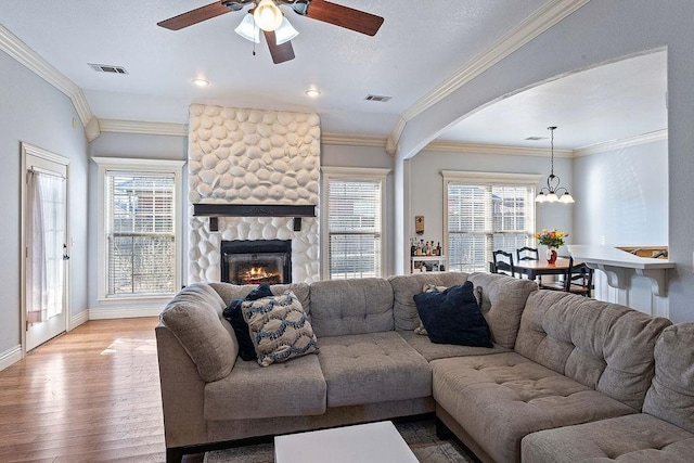 living area featuring a wealth of natural light, visible vents, hardwood / wood-style flooring, and ceiling fan with notable chandelier