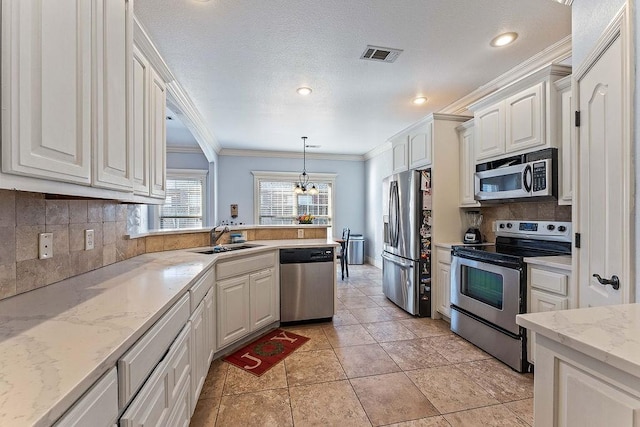 kitchen featuring visible vents, a sink, white cabinetry, appliances with stainless steel finishes, and crown molding