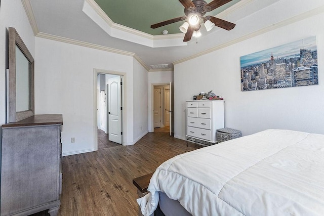 bedroom with visible vents, baseboards, ornamental molding, wood finished floors, and a raised ceiling