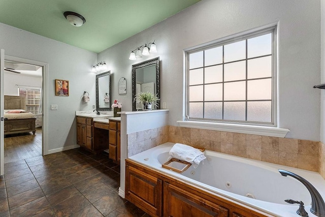 bathroom featuring a tub with jets, ensuite bath, and vanity