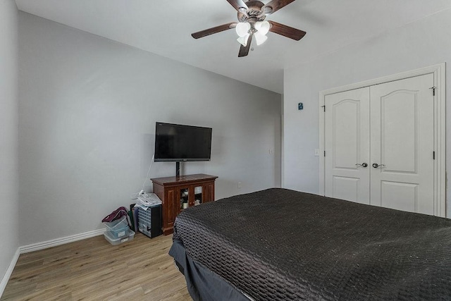 bedroom with light wood-style flooring, baseboards, a closet, and ceiling fan