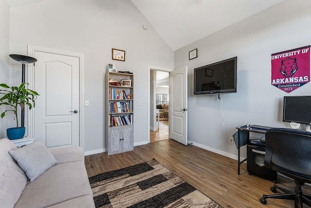 office space with baseboards, high vaulted ceiling, and wood finished floors