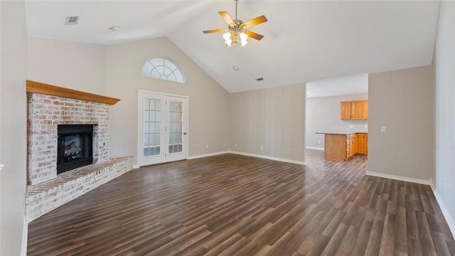 unfurnished living room with dark wood-style floors, a fireplace, baseboards, and ceiling fan