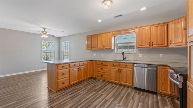 kitchen featuring visible vents, a peninsula, ceiling fan, a sink, and appliances with stainless steel finishes