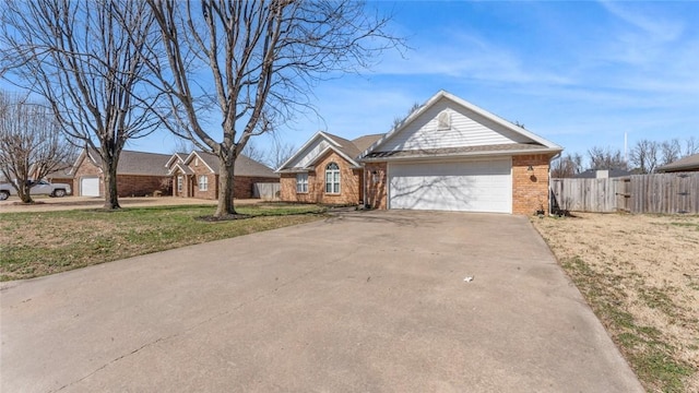 ranch-style house featuring a front yard, fence, driveway, a garage, and brick siding