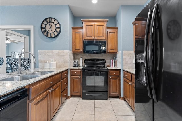 kitchen with brown cabinetry, black appliances, a ceiling fan, and a sink