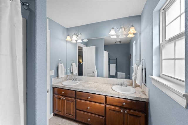 full bathroom featuring double vanity, tile patterned floors, a shower with shower curtain, and a sink