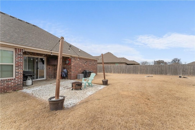 view of yard featuring a patio area, a fire pit, and a fenced backyard