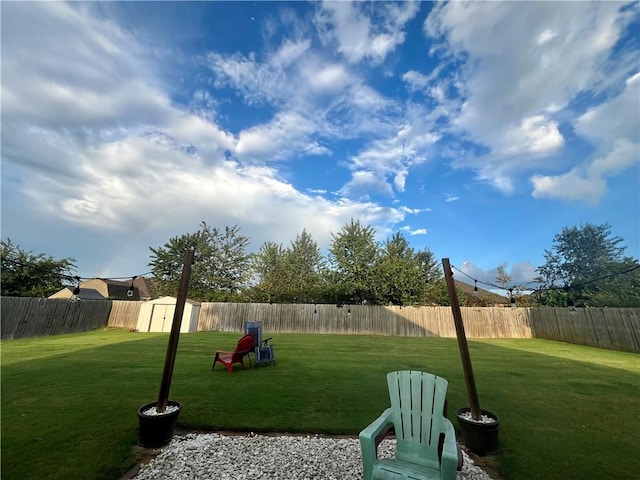 view of yard featuring an outdoor structure, a storage unit, and a fenced backyard