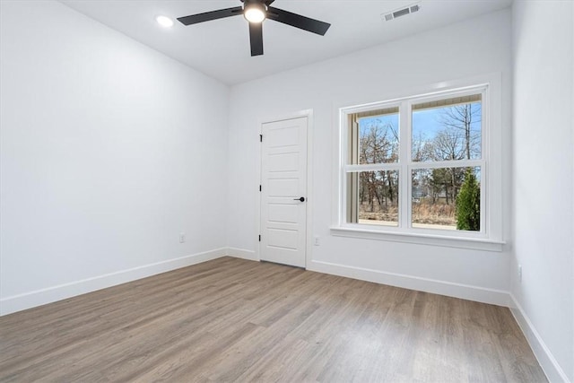 unfurnished room with visible vents, baseboards, light wood-style floors, and ceiling fan